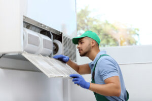 Professional technician maintaining modern air conditioner